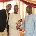 Suraj Oyewale (m), presenting plaque to Akeem (r), assisted by a participant 