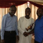 Mr. Niyi Yusuf (r), CEO, Accenture Nigeria, being presented with his plaque by Jarus (m), with Mayowa Akinsola